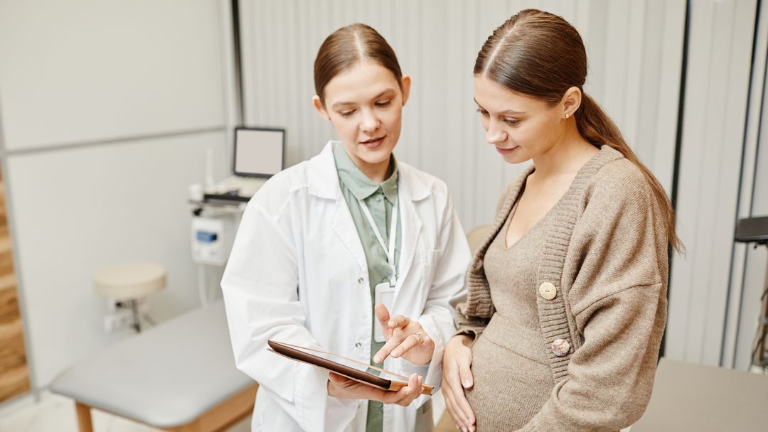 doctor talking to pregnant woman in clinic